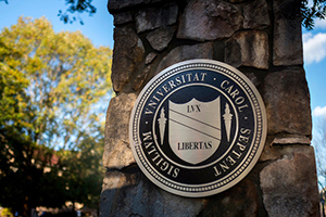 The seal of the University of North Carolina at Chapel Hill affixed to a stone pillar at the Cameron Avenue entrance.